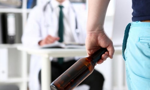 мужчина с бутылкой стоит напротив врача